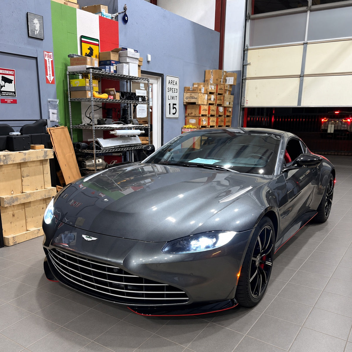 Gray Aston Martin in the GTE Engineering workshop with gray tile flooring