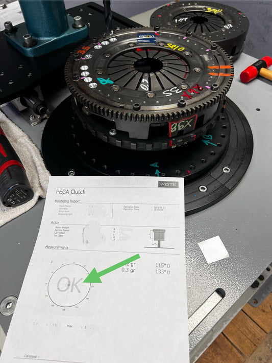 Clutch assembly on balancing fixture beside inspection paperwork