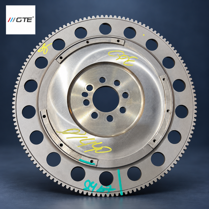 Aston Martin lightweight upgrade flywheel service example with lightening holes, mounting points and inspection marks; identify its maker and installed clutch