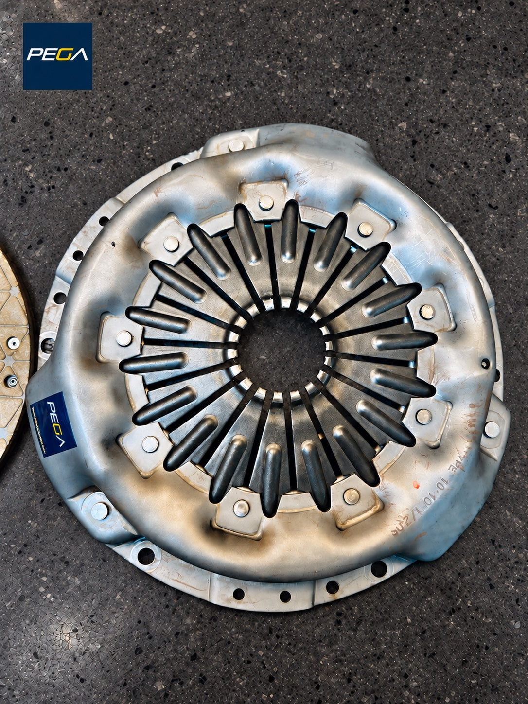 Aston Martin V12 Vantage S clutch rebuild service example showing the pressure-plate diaphragm and PEGA branding