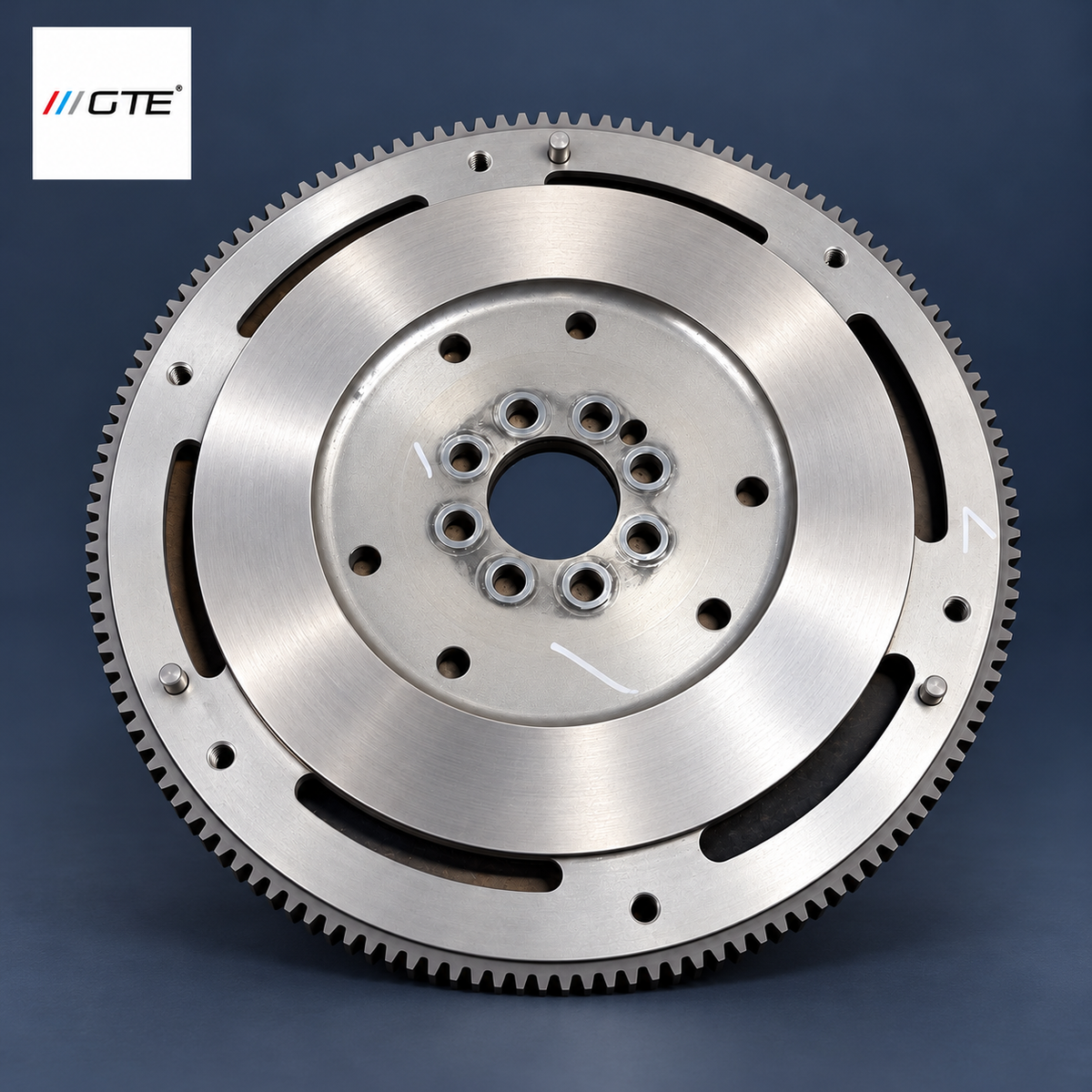 Aston Martin V8 Vantage flywheel service example showing machined friction face, mounting holes, dowels and white inspection marks
