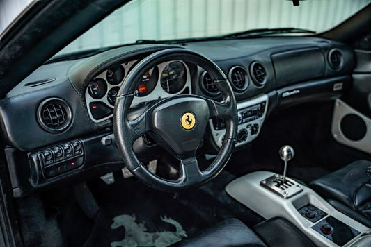 Ferrari 360 interior with a gated manual lever, black seats and dashboard; installation example.