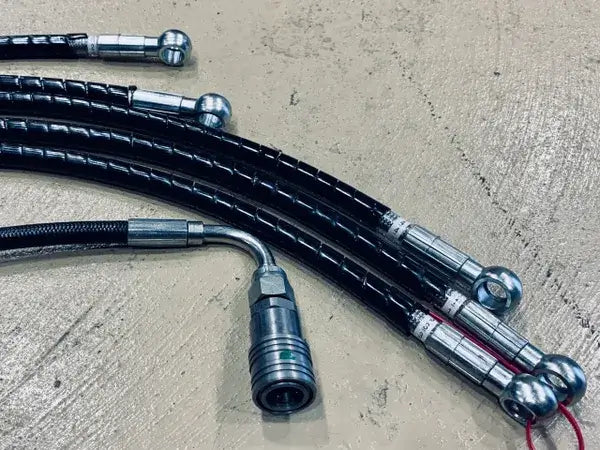 Shared Ferrari hydraulic-hose workmanship example showing banjo ends, crimp sleeves and a quick-coupler; not a part-specific kit or included quantity